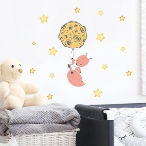 Detail of fox and moon wall stickers in a cozy nursery room with warm starry accents
