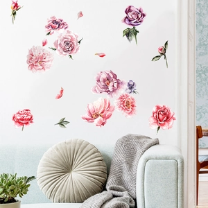 Close-up of watercolor peony and rose wall stickers on a white wall above a sofa