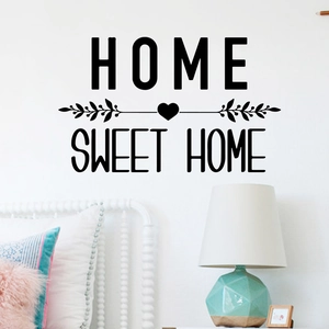 Detail of Home Sweet Home wall decal with heart and leaf accents in a cozy bedroom decor