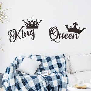 Close-up of black vinyl King and Queen crown wall decals displayed over a white sofa