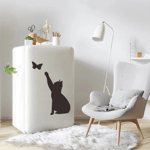 Detail view of a black cat silhouette wall sticker reaching for butterflies on a white fridge
