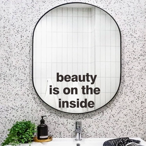 Oval black framed wall mirror with 'Beauty is on the inside' text for home decor