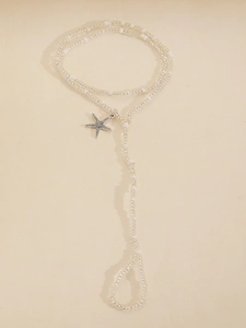 Macro shot of boho starfish charm anklet with transparent and white beads for beach wear