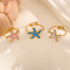 Tre anelli a forma di stella marina colorati in rosa, blu e bianco su un piatto