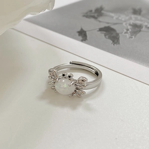 Detalle macro del anillo de cangrejo ajustable con piedra de ópalo y garras de cristal