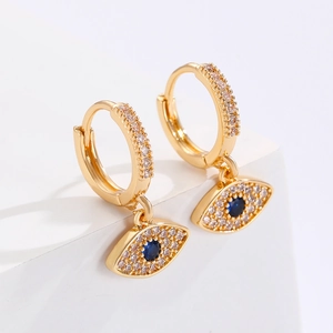 Close-up of gold evil eye earrings with blue zircon center and pavé crystal hoop