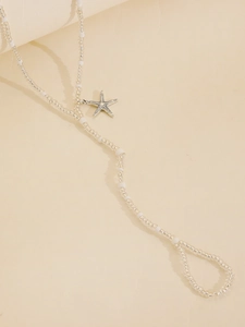 Detail of beaded starfish toe anklet with clear beads and white pearls for beach wear