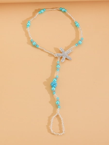 Detailed close-up of bohemian beaded barefoot sandal with starfish pendant for beach wear