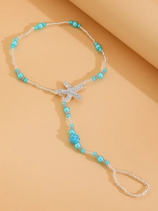 Detail of beaded starfish anklet with blue beads and rhinestone charm for beach style