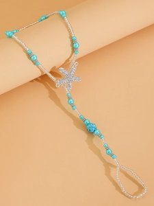 Detail of beaded starfish toe ring anklet with blue pearls and sparkling rhinestones