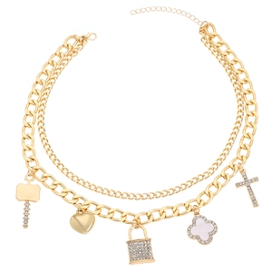 Macro shot of gold layered chain necklace featuring lock, heart, and cross charms