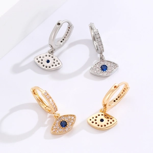 Detail of gold and silver devil eye hoop earrings with sparkling blue zircon stones