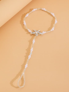 Detail of beaded starfish toe ring anklet with pearls and rhinestones for beach weddings