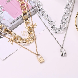 Macro shot of gold and silver chunky double-layer padlock pendant necklaces displayed flat