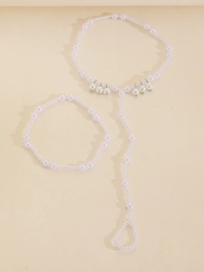 Detailed view of white faux pearl beaded ankle chain with starfish drop accents