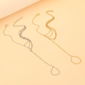 Detail view of gold and silver boho slave bracelets with layered chains and finger rings