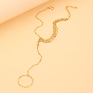 Detail of gold layered hand chain with starfish beads and finger ring for women