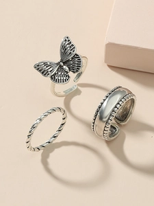 Detailed close-up of retro silver rings featuring a butterfly and beaded metal band