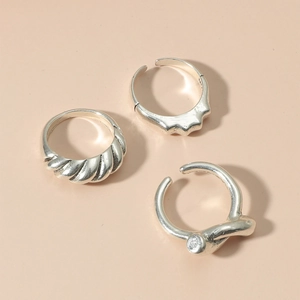 Detailed view of silver hollow heart rings set with twisted rope and knot textures