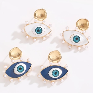 Detailed close-up of Evil Eye earrings with blue enamel and gold pearl trim