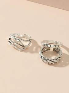 Detailed close-up of vintage silver hollow heart rings with Roman numerals and textures