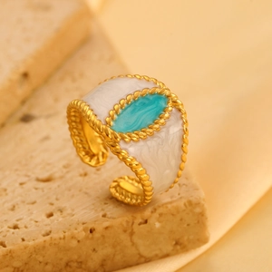 Detailweergave van de gouden open ring met blauwe turkoois en witte emaille decoratie