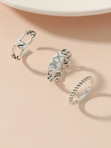 Detailed view of three vintage silver rings with chain and ethnic engraved patterns