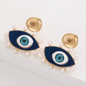 Detailed view of evil eye earrings featuring blue enamel and white pearls on gold alloy