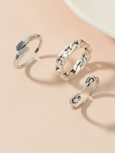 Detailed close-up of retro silver rings featuring hollow cross and chain link designs