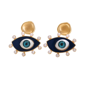 Detail of blue enamel Evil Eye earring with white pearls and gold wave textured metal