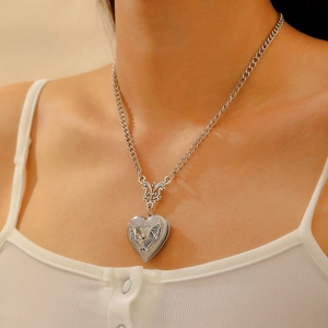 Detail of vintage silver heart locket with butterfly engraving on a delicate chain