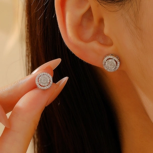 Close-up of silver-tone round stud earrings featuring micro-pave white cubic zirconia