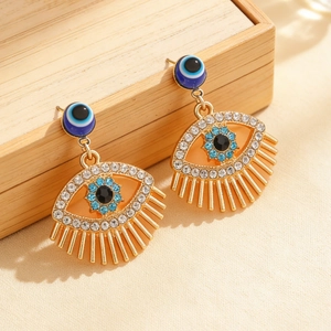 Detailed close-up of evil eye hoop earrings with blue zircon inlays on a wood box
