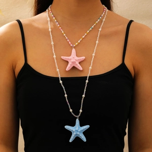Détail d'un collier superposé à pendentif étoile de mer avec perles colorées sur un mannequin