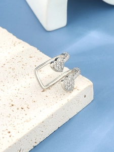 Detail eines silbernen U-förmigen offenen Rings mit Herz-Zirkonia-Akzenten auf Stein