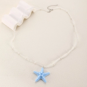 Détail du collier pendentif étoile de mer bleu clair avec perles blanches et fermoir mousqueton