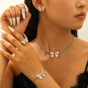 Nahaufnahme des eleganten silbernen Schleifen-Schmucksets mit Kette, Armband, Ring und Ohrringen