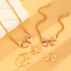 Detail eines eleganten goldenen Schleifen-Schmucksets mit Halskette, Armband, Ring und Ohrringen