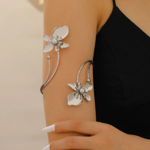 Detail of silver flower arm cuff with mirror finish petals and woven texture band