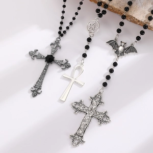 Detail view of gothic beaded necklaces with silver cross, ankh, and bat charms