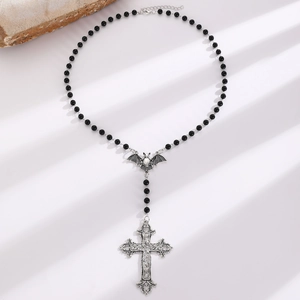 Detail of Gothic beaded necklace featuring a silver bat charm and ornate cross pendant