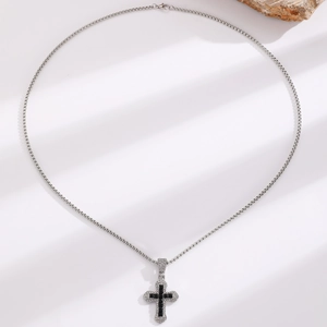 Macro view of Gothic silver box chain and black square gem cross pendant with white stones