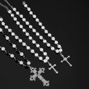 Detail of beaded cross pendant necklaces featuring vintage silver plating and white pearls