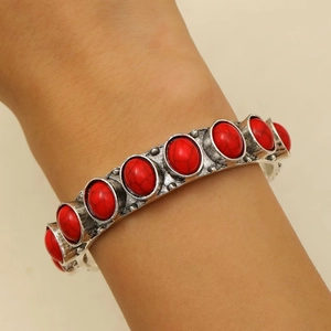 Detail of bohemian silver bracelet with nine oval red stones on a model's wrist
