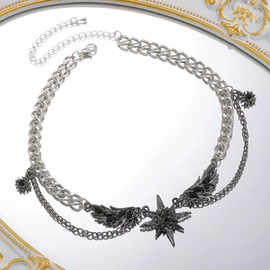 Close-up of gothic silver layered necklace with black star pendant and wing details