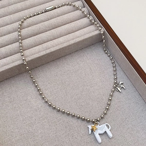 Detailansicht einer silbernen Kugelkette mit weißem Emaille Pony-Anhänger und Goldstern