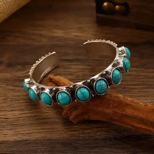 Detailed view of bohemian style open cuff bracelet with turquoise stones and vintage silver finish