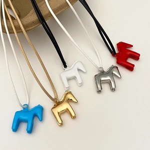 Nahaufnahme bunter Emaille-Pony-Anhänger an gewebten Ketten in Gold Silber und Rot