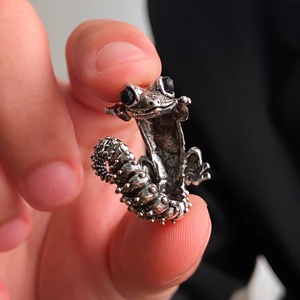 Macro view of gothic silver lizard ring featuring black gem eyes and detailed scale texture
