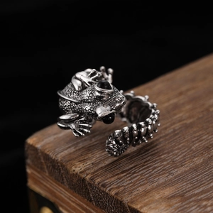 Macro shot of a gothic frog ring with black gemstone eyes and vintage silver texture